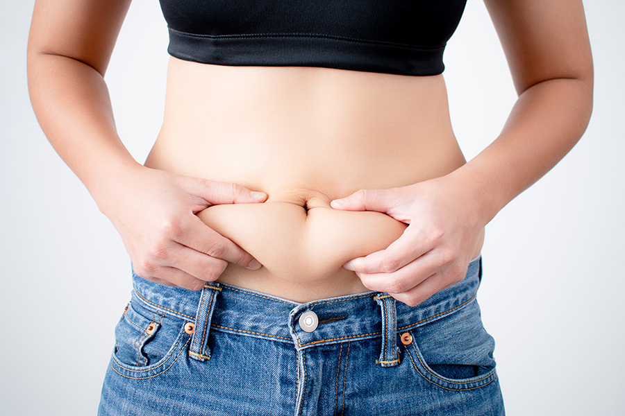 Woman holding excess fat on her belly