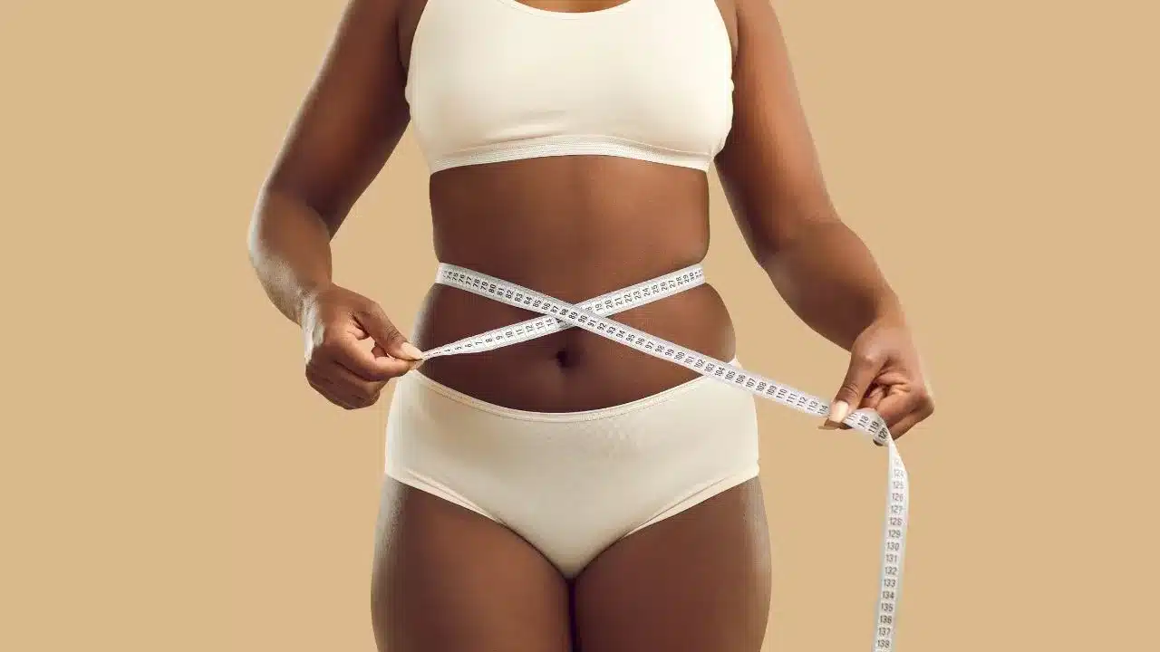 Overweight black girl make measurement before diet